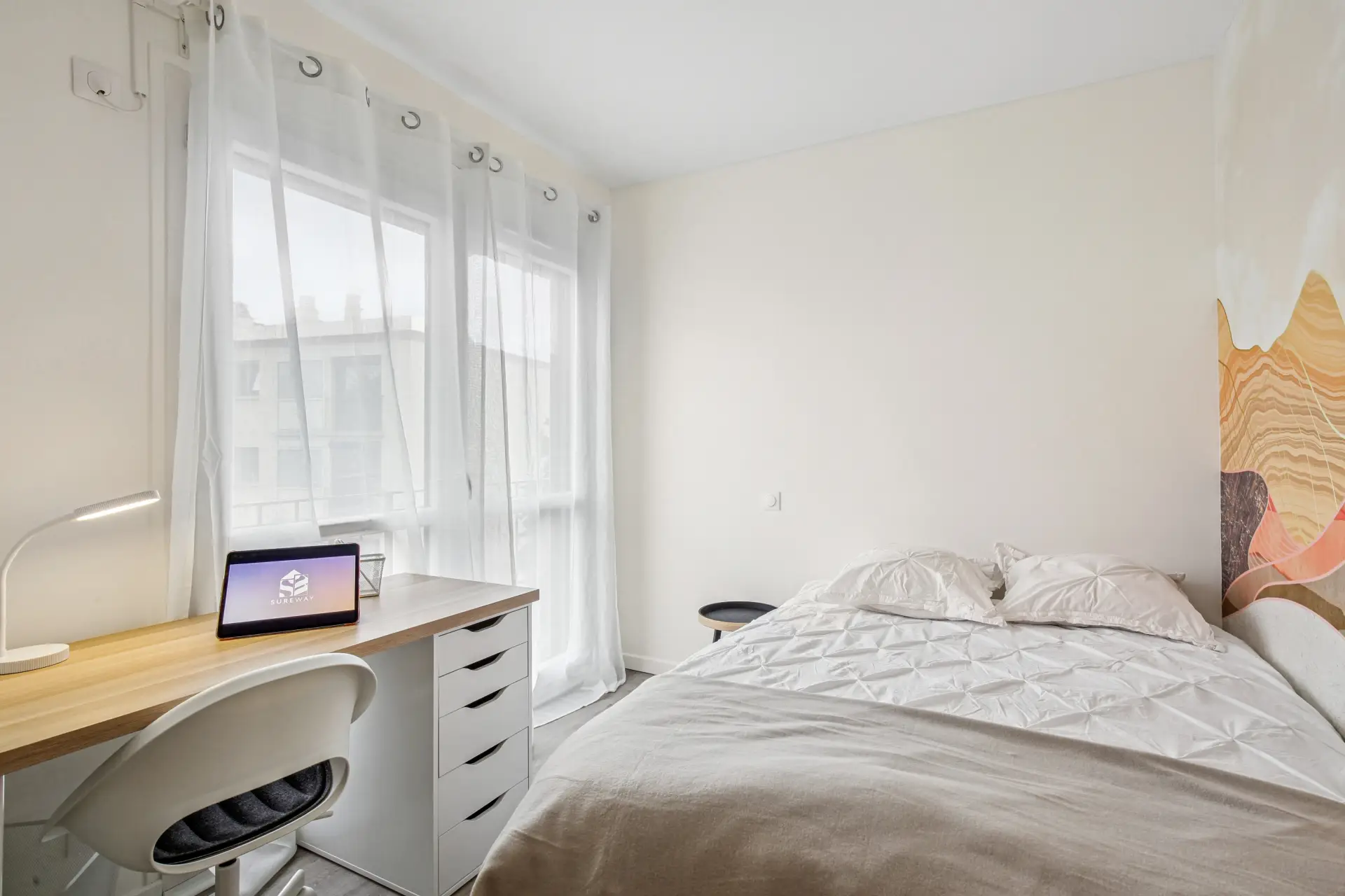 Chambre avec lit, bureau et papier peint coloré au mur