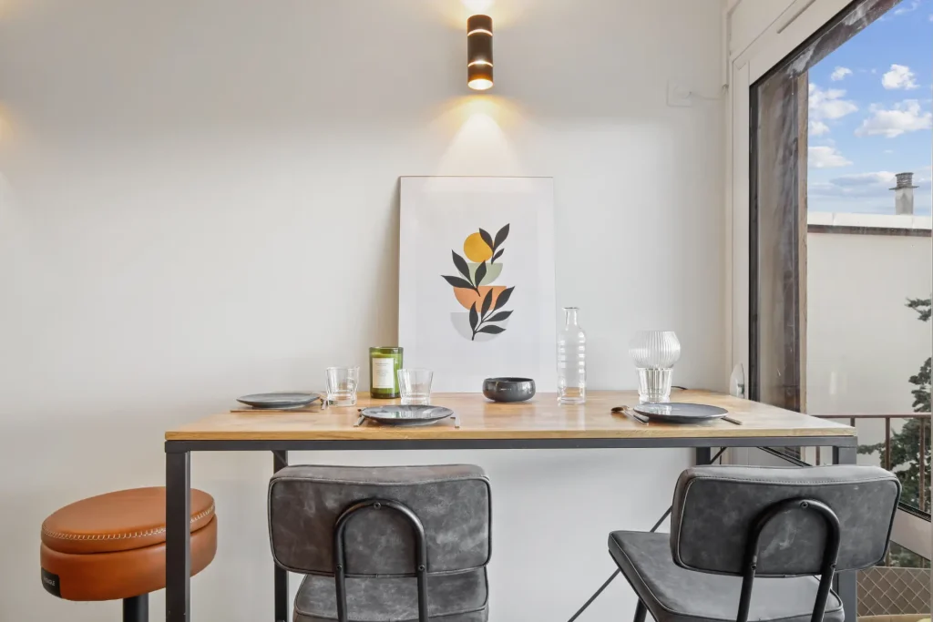 Coin salle à manger, avec table haute et vue sur la terrasse extérieure