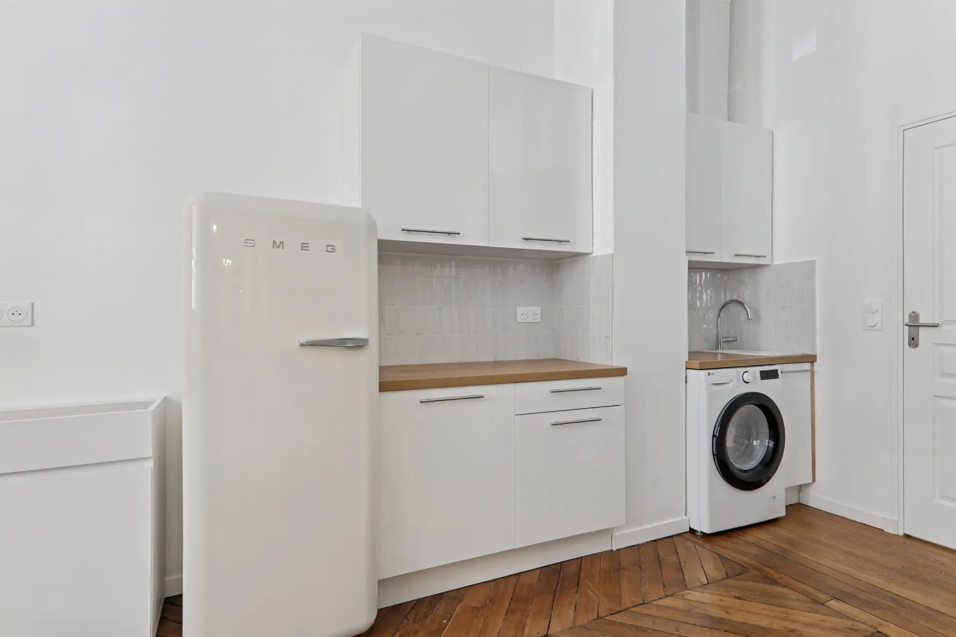 Cuisine avec mobilier blanc et bois, avec machine à laver et frigo SMEG blanc