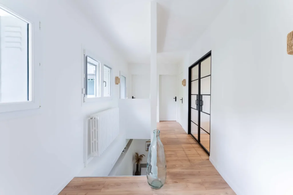 Étage de bureaux d'entreprise, avec vue sur les escaliers et les bureaux individuels ; projet de rénovation suivi par sureway