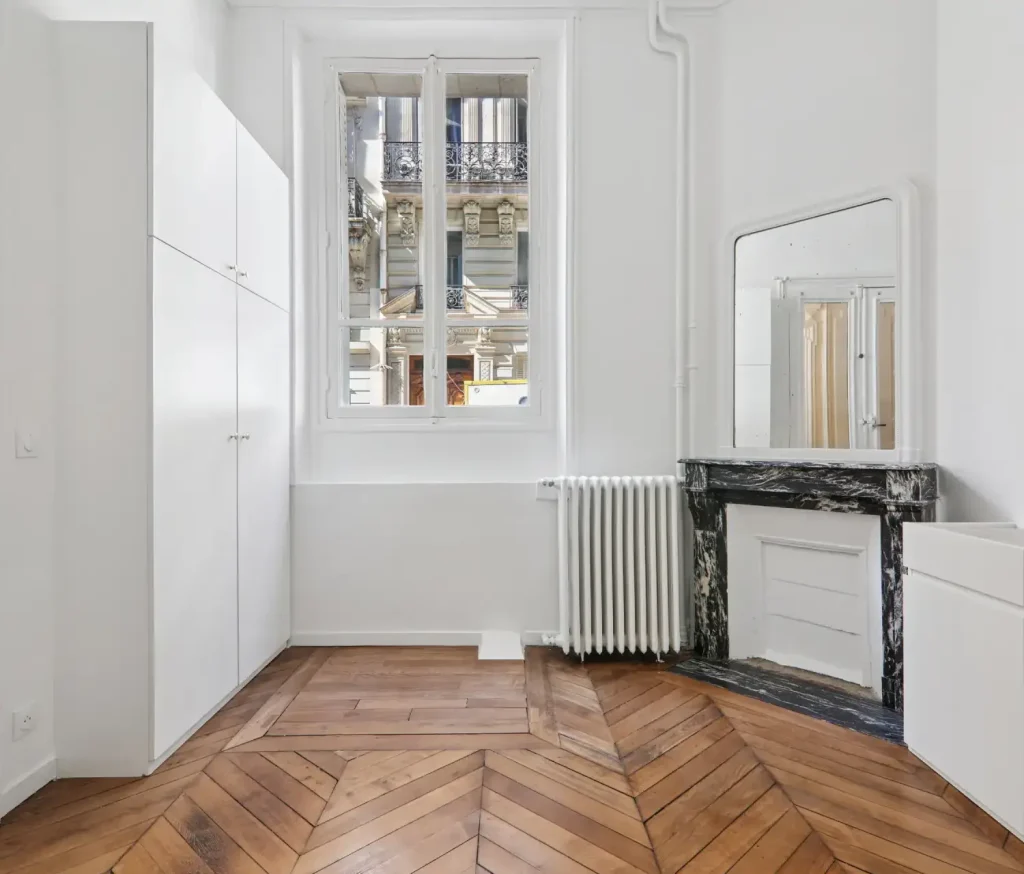 Vue sur la cheminée et la fenêtre dans le studio à paris 16ème