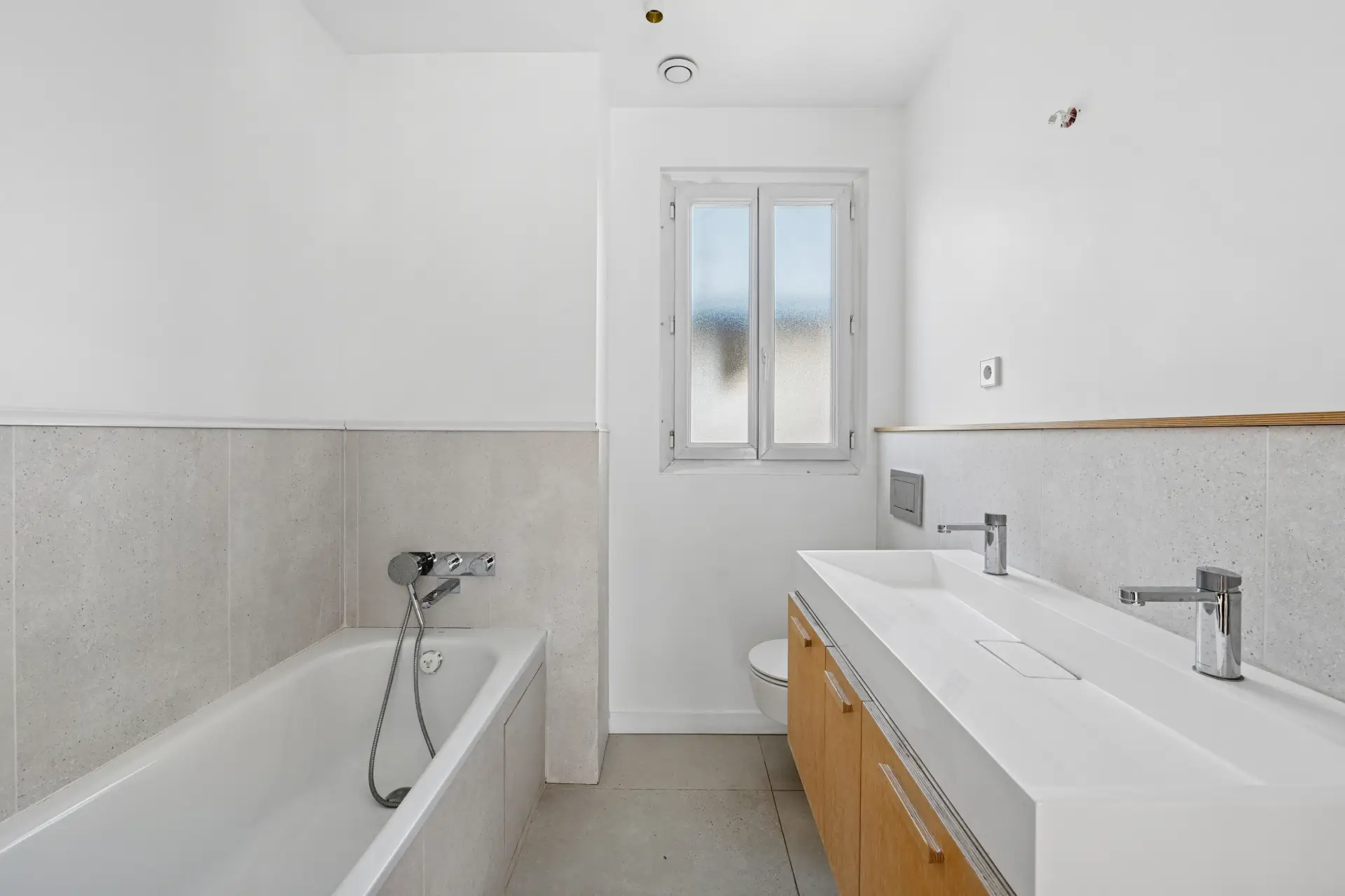 Salle de bain avec baignoire, toilettes et double vasque, rénovée par Sureway